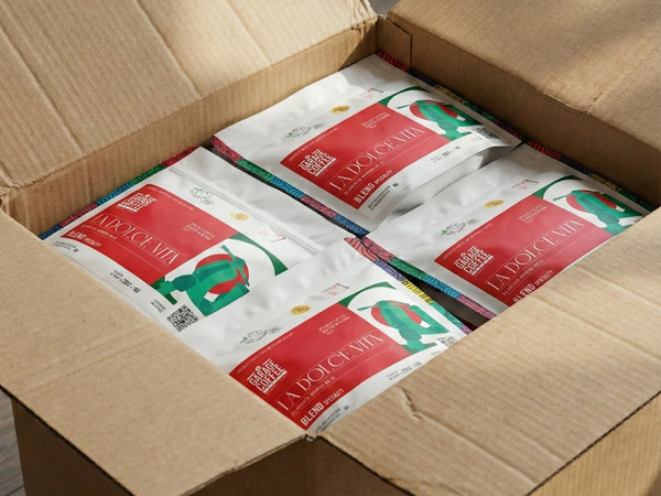 A cardboard box containing multiple bags of specialty coffee from Garage Coffee Bros featuring 'La Dolce Vita' blend.