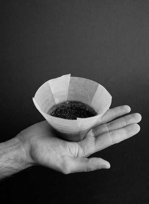 Sibarist FLAT flat-bottom coffee filter held in hand showing smooth ungrooved design